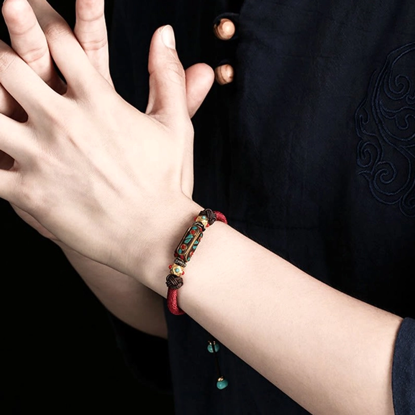 Worn turquoise Om Mani Padme Hum Buddhist bracelet on wrist worn with ethnic embroidered traditional clothing, demonstrating compact comfortable fit
