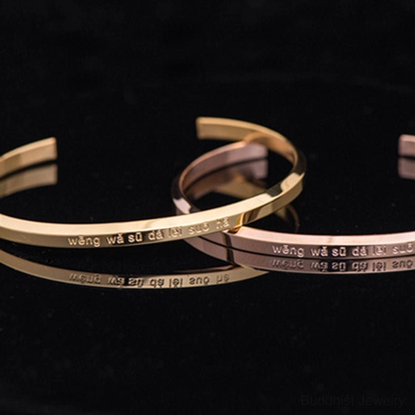 Multiple sacred mantra bracelets in gold and rose gold with engraved text