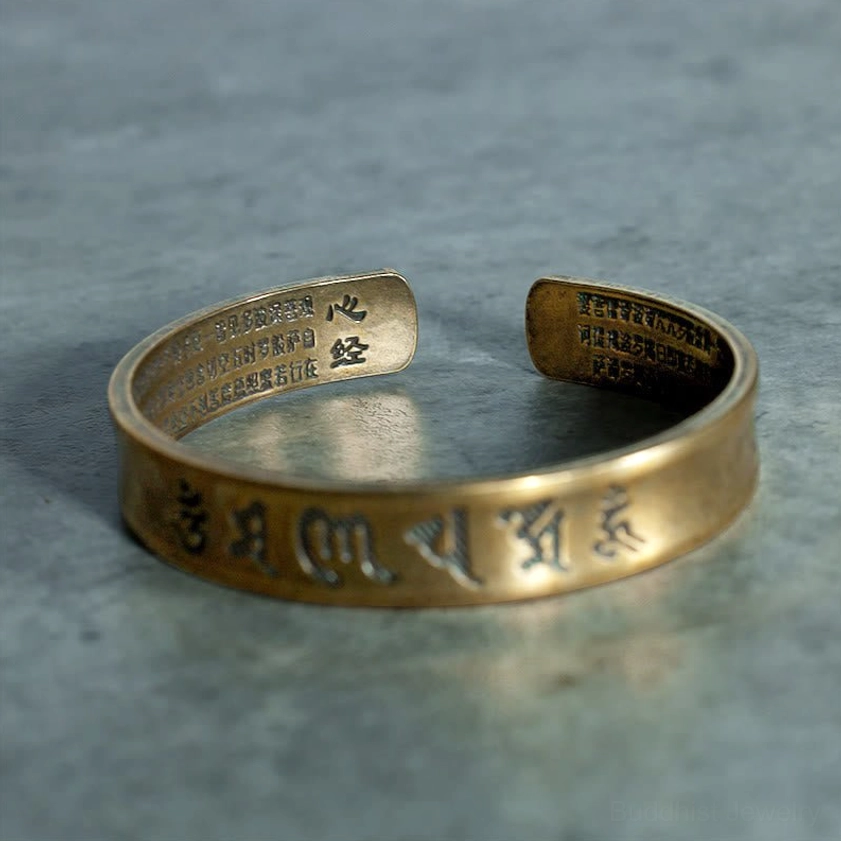 Brass mantra bracelet with polished finish, six-word mantra engraved on top band and Buddhist texts on inside