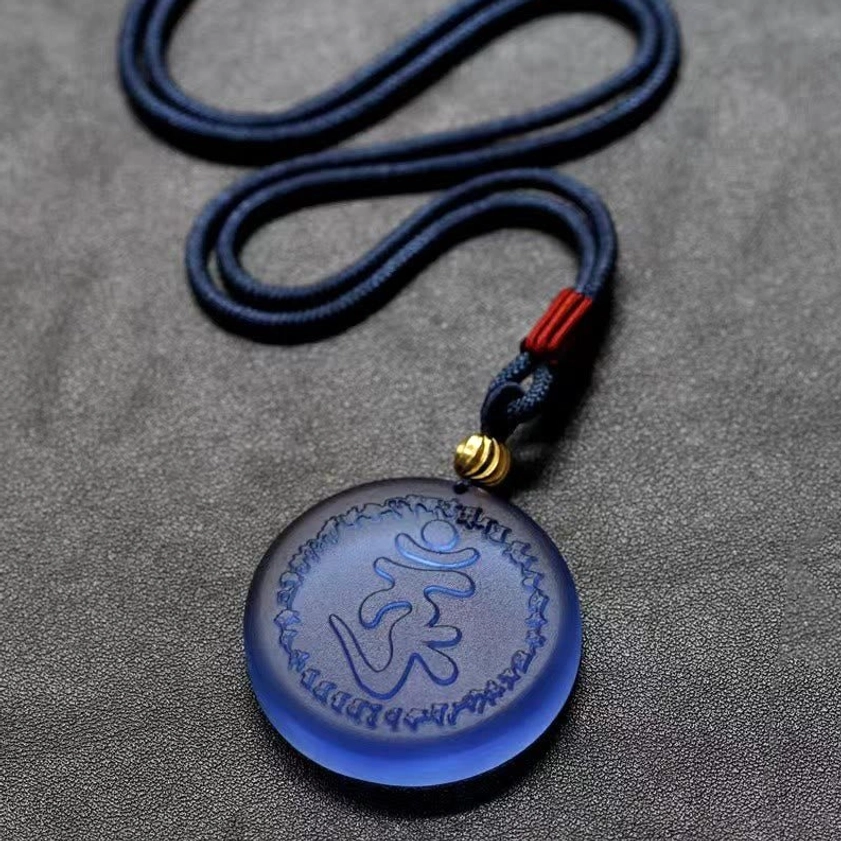 Buddhist Shurangama Mantra necklace flat lay showing navy rope cord with red knot and gold spacer connector