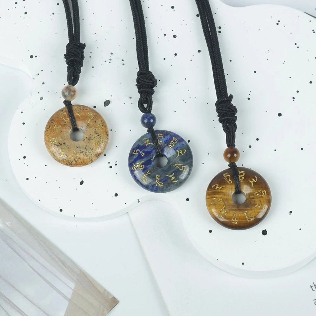 Buddhist mantra pendant necklace collection showing multiple crystal variants with golden engraved Sanskrit text