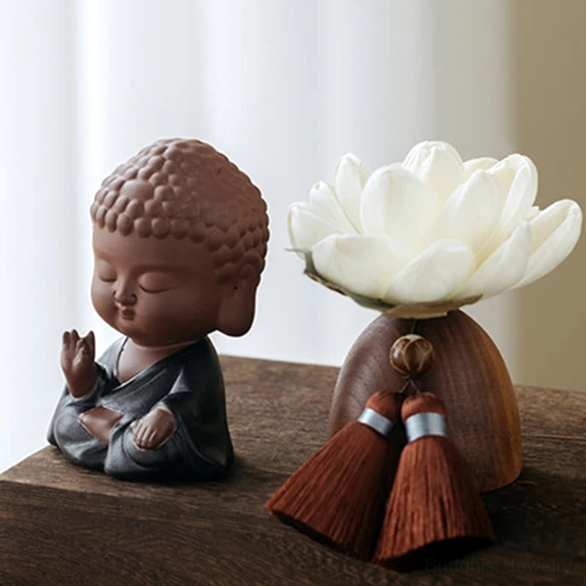 Buddhist meditating Buddha figurine in black robe with serene expression on wooden desk