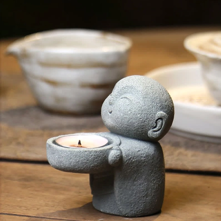 Meditation candle holder with unlit tealight on wooden table - left side angle showing monk figure detail