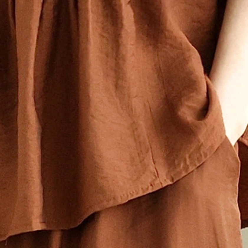 Organic cotton meditation shirt fabric texture - wrinkled natural material with layered hem detail