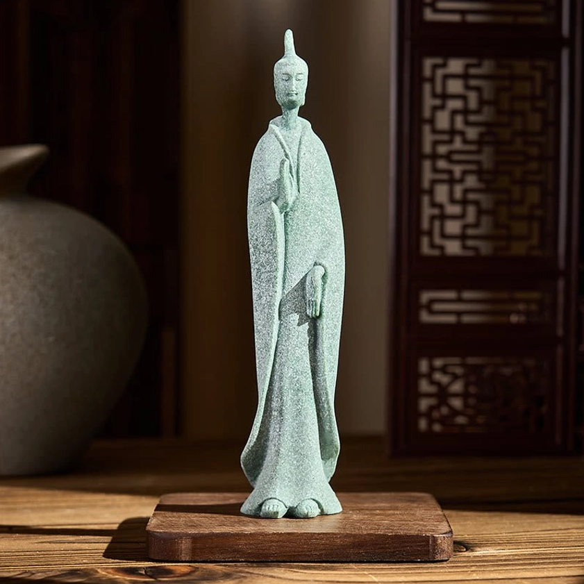 Handcrafted standing Buddha statue on wooden base displayed in home interior setting with decorative items