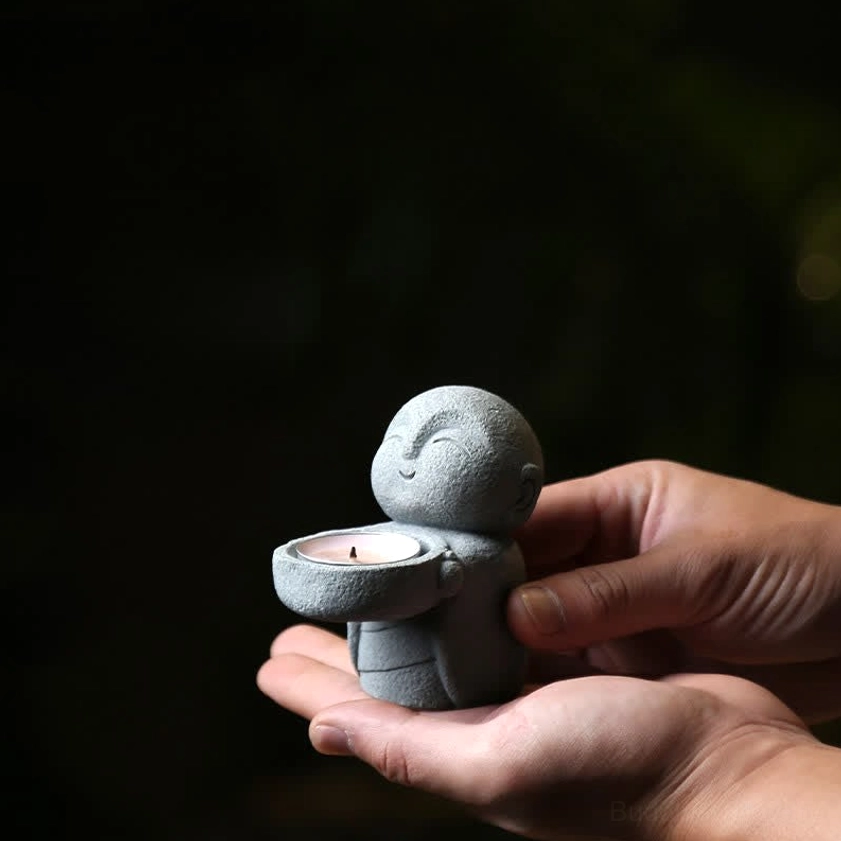 Mini Buddhist monk candle holder held in hand - palm size meditation decor demonstrating compact portable design