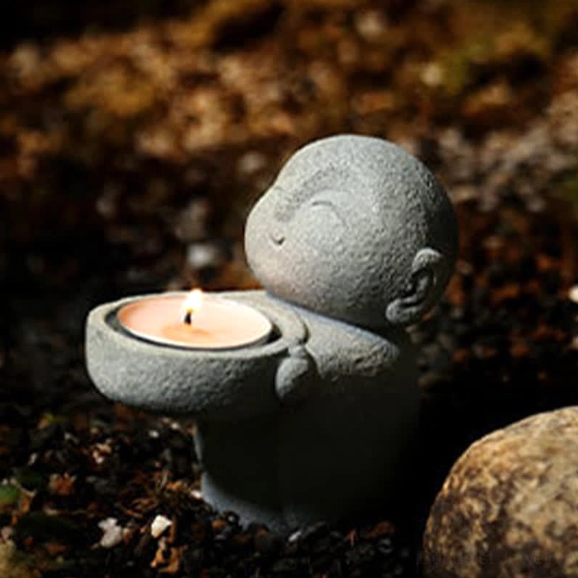 Handmade Buddhist candle holder in garden setting - left side view with grey matte stone finish