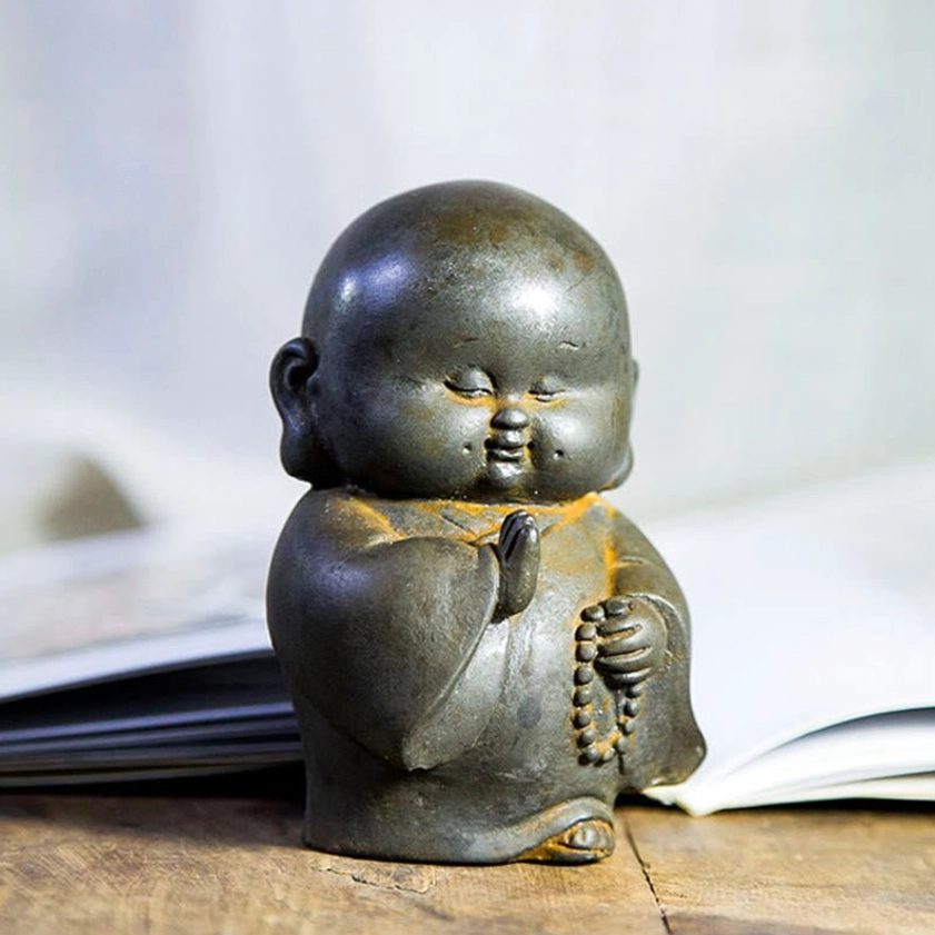 Iron powder Buddhist monk ornament front view with dark grey finish and rust accents in classic meditation pose