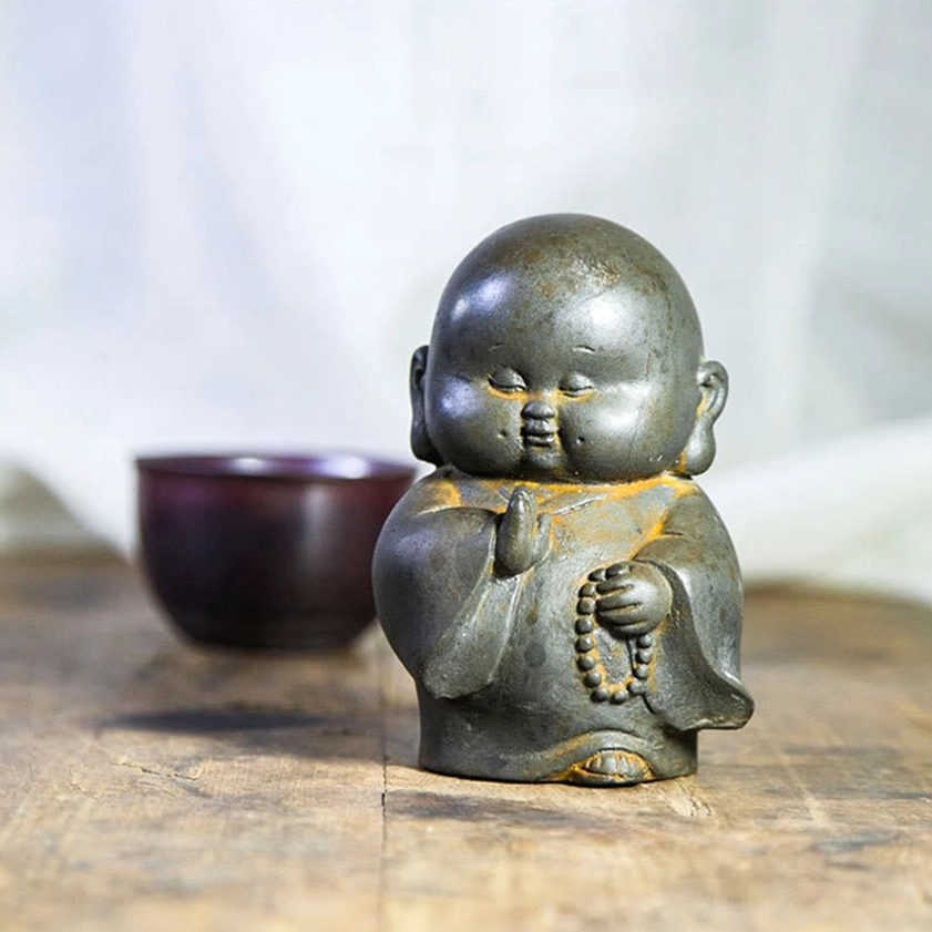Cute chubby Buddhist monk resin decoration in front perspective with prayer beads, rustic aged finish