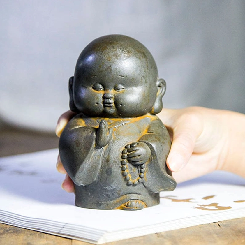 Handcrafted Buddhist monk iron powder statue showing front angle with intricate robes and serene expression