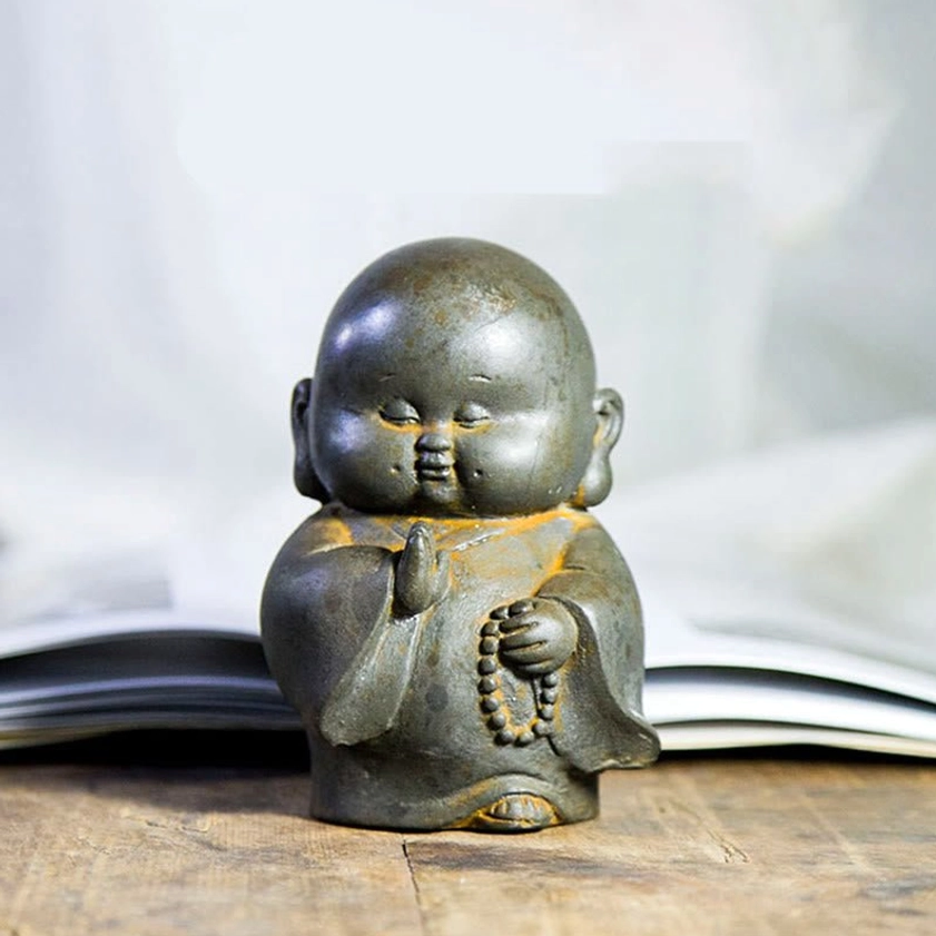 Iron powder resin Buddhist monk statue with weathered rust yellow accents and aged patina, frontal display perspective