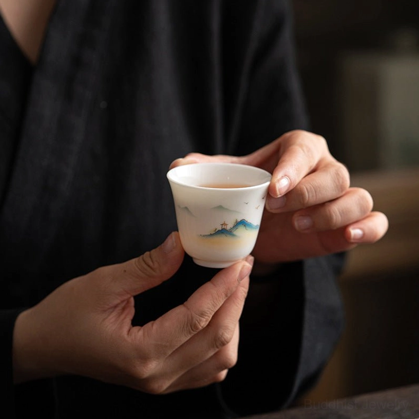 Buddhist porcelain tea cup featuring spiritual mountain and pavilion landscape artwork, premium handmade ceramic piece
