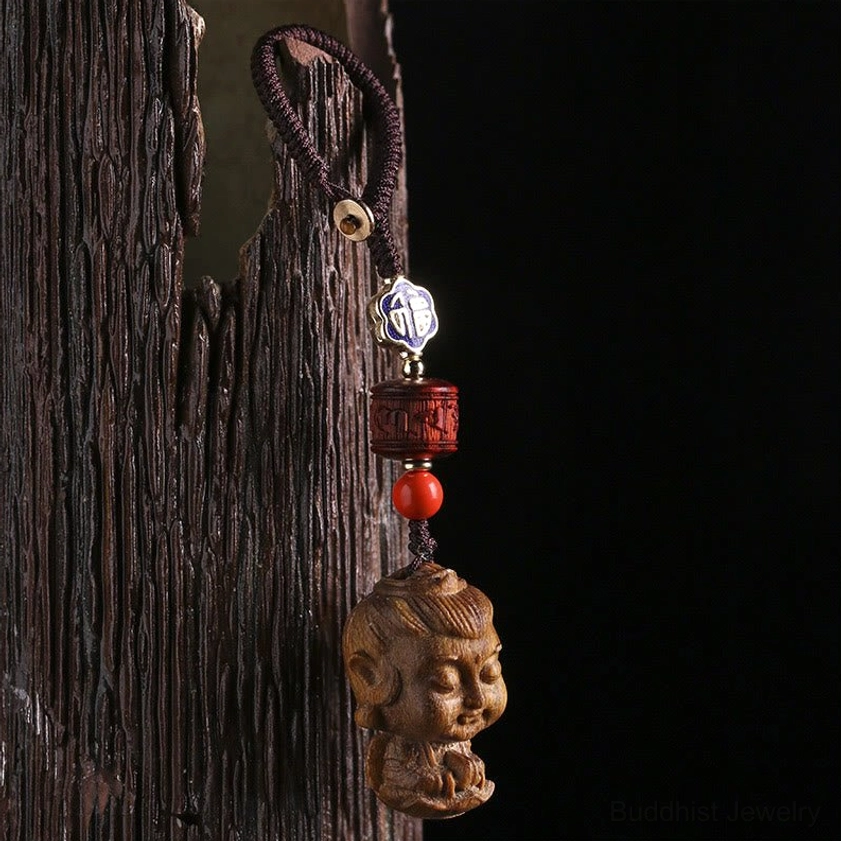 Buddhist natal buddha keychain side close-up with carved wooden Buddha head braided cord and cinnabar accent beads
