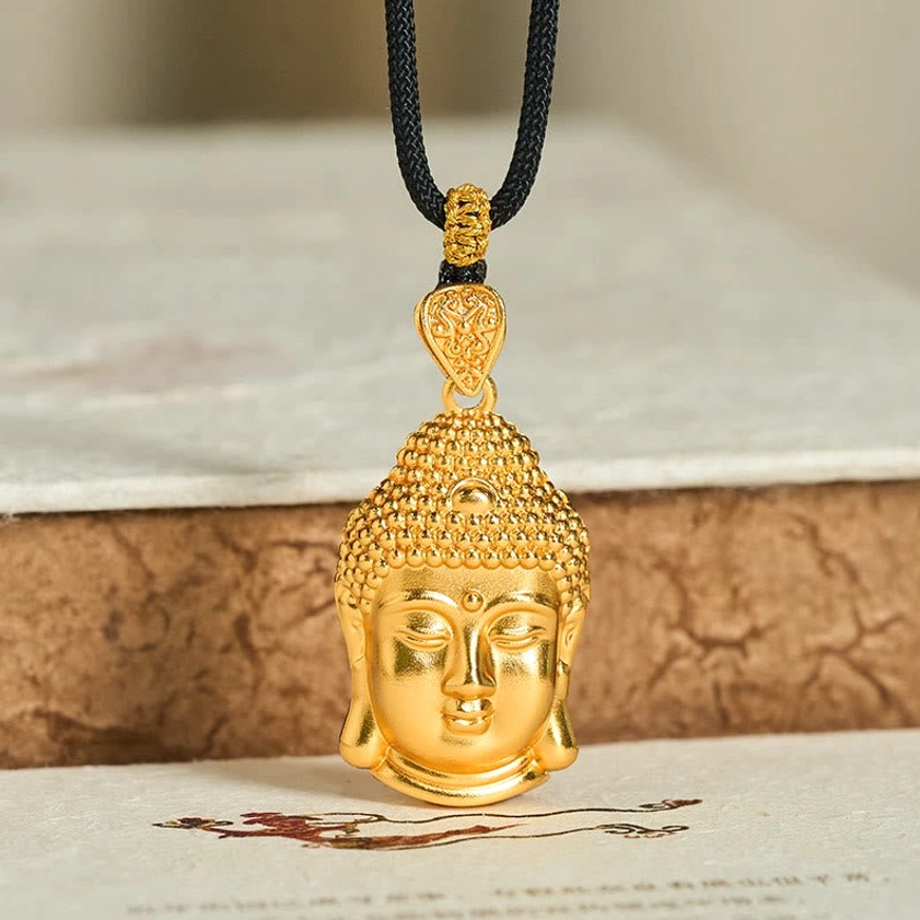 Gold Buddha pendant necklace lifestyle display on braided black cord