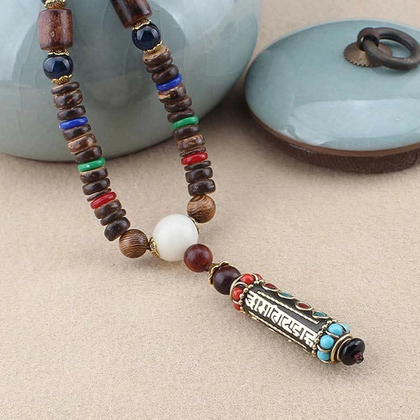 Buddhist pendant necklace with mixed gemstone beads styled with ceramic tea set, mindfulness lifestyle shot
