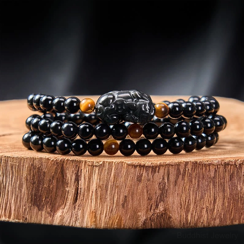 Buddhist obsidian Pixiu bracelet detail shot showcasing hand-carved charm and natural stone craftsmanship