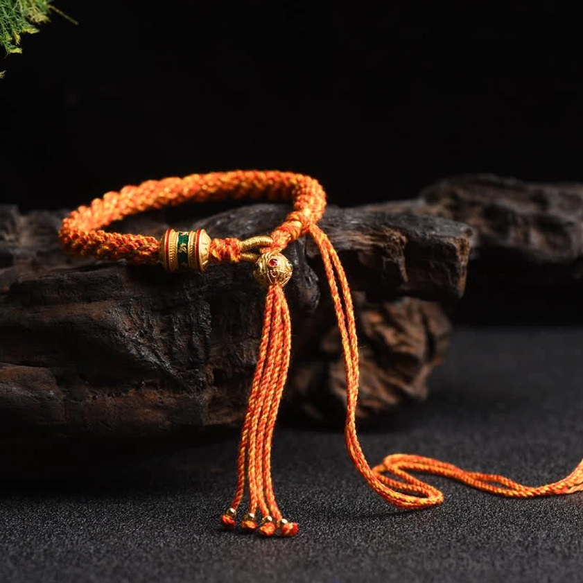 Orange Buddhist lucky charm string bracelet with prayer wheel bead and handcrafted woven rope construction