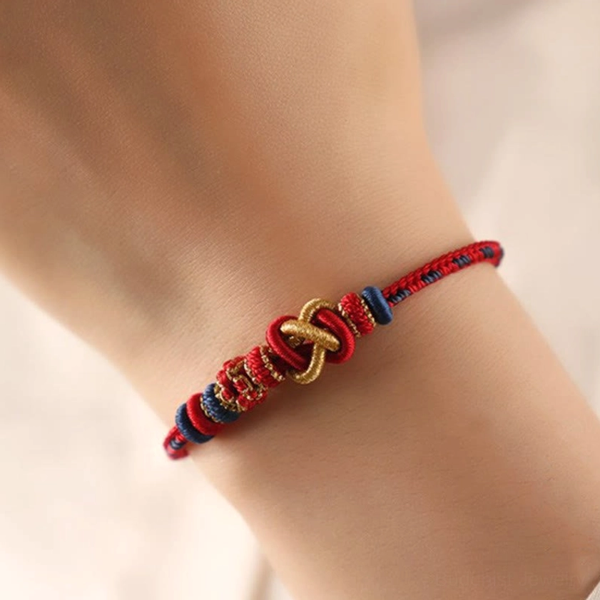 Colorful Buddhist peace knot bracelet worn on wrist showing red blue and gold tones with slim comfortable fit for spiritual protection