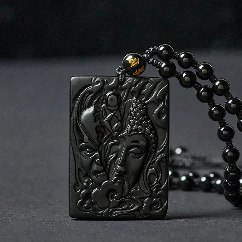 Buddhist obsidian demon buddha pendant necklace front view showing carved dual-face relief and decorative clasp bead