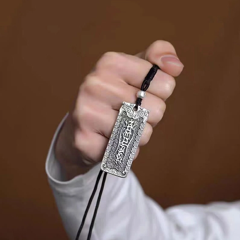 Handheld Buddhist mantra necklace pendant showing compact design and adjustable black cord with beads
