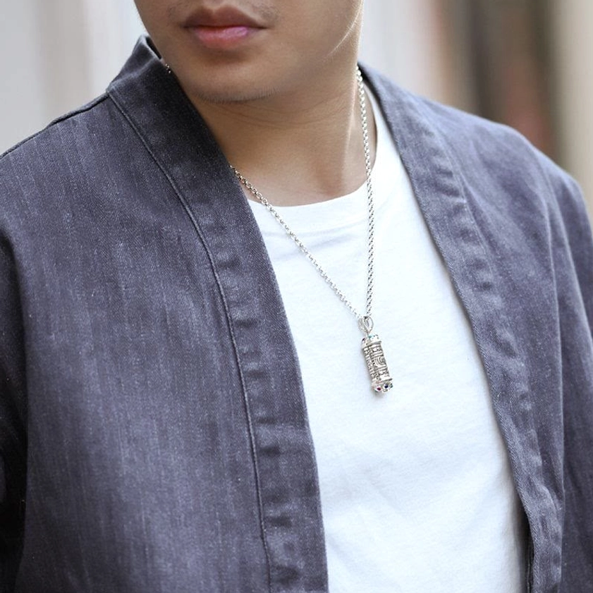 Buddhist Om Mani Padme Hum pendant necklace worn as casual everyday jewelry on male model