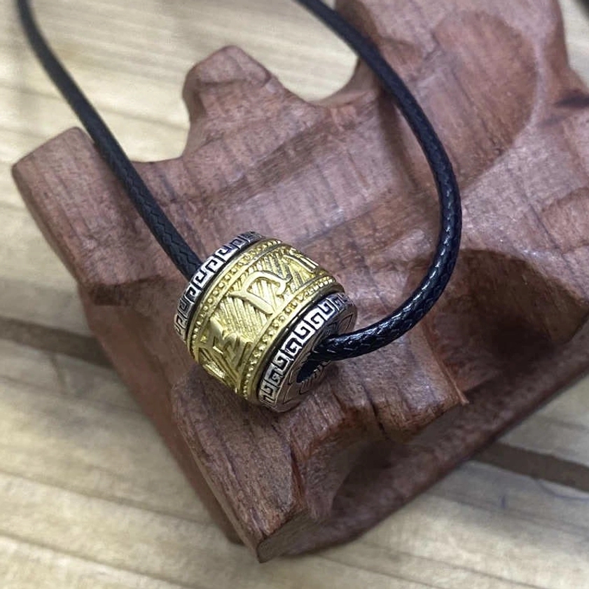 Two-tone Buddhist protection pendant on black wax cord, mixed gold and silver carved mantra necklace