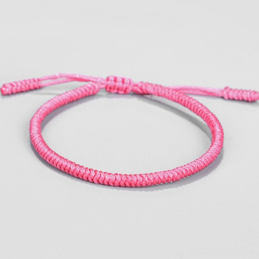 Light pink solid-color Buddhist string bracelet with tight woven texture and adjustable knot for wrist sizing