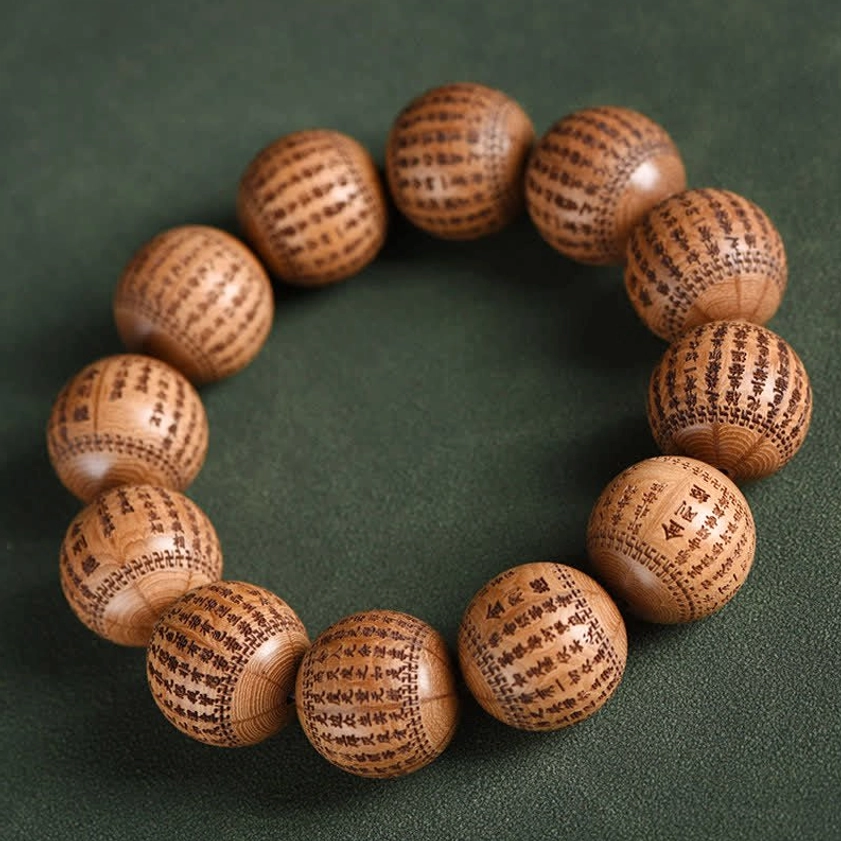 Medium Abelia Biflora wood prayer bracelet with elastic string on dark green fabric background
