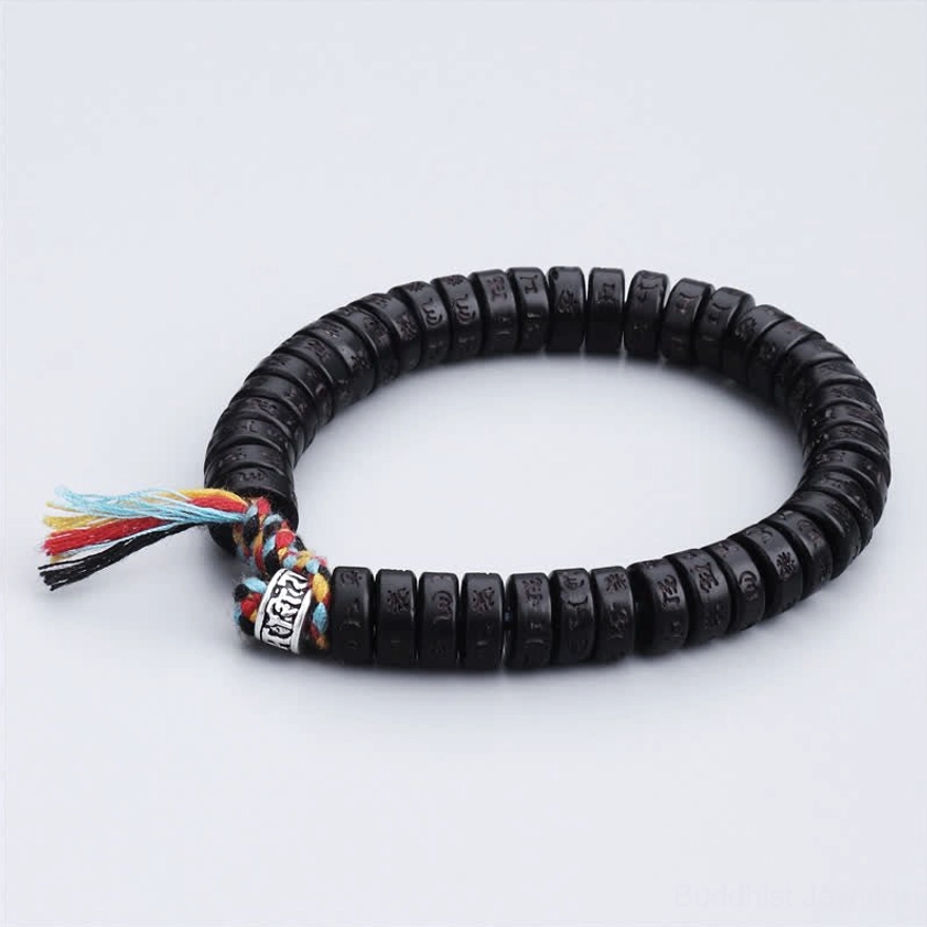 Buddhist prayer bracelet with colorful tassel closure and engraved disc beads, featuring silver metal accent charm