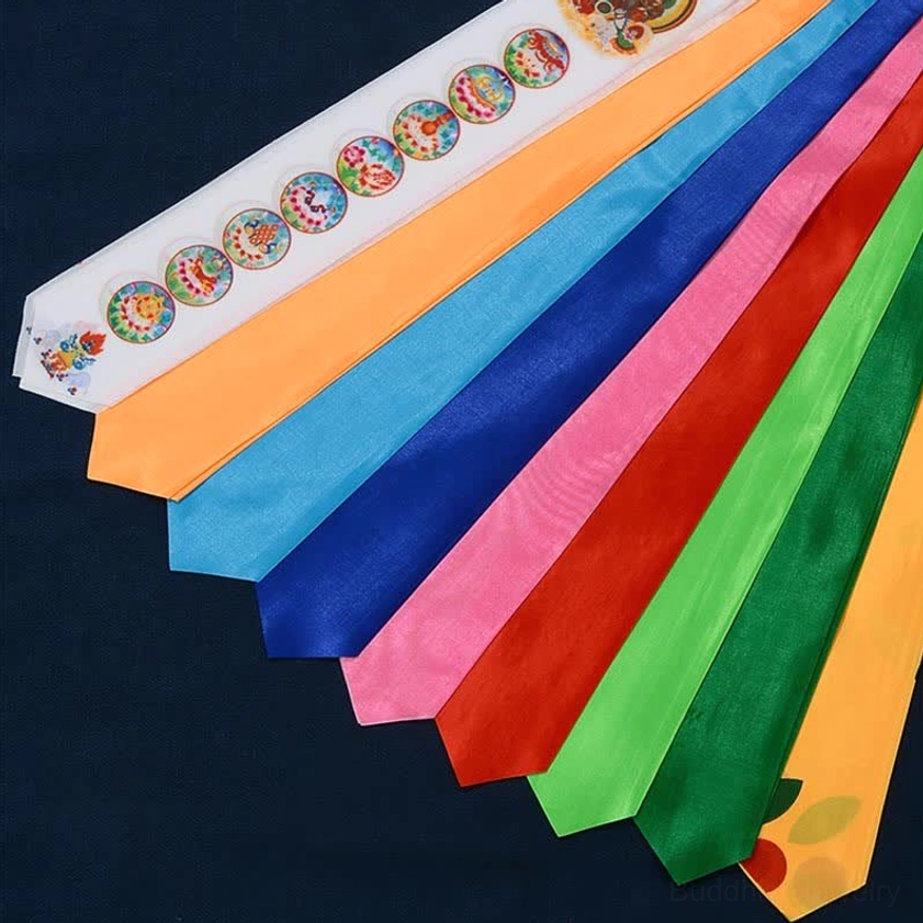 Unfolded Buddhist prayer flag strips showing seven rainbow color layers with circular auspicious symbol prints