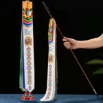 Buddhist prayer flag with windhorse and auspicious symbols displayed on wooden pole with metal mirror decor