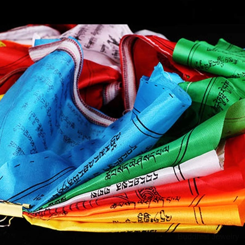 Stacked Buddhist prayer flags close-up showing individual flag details with five vibrant colors and hand-printed scriptures