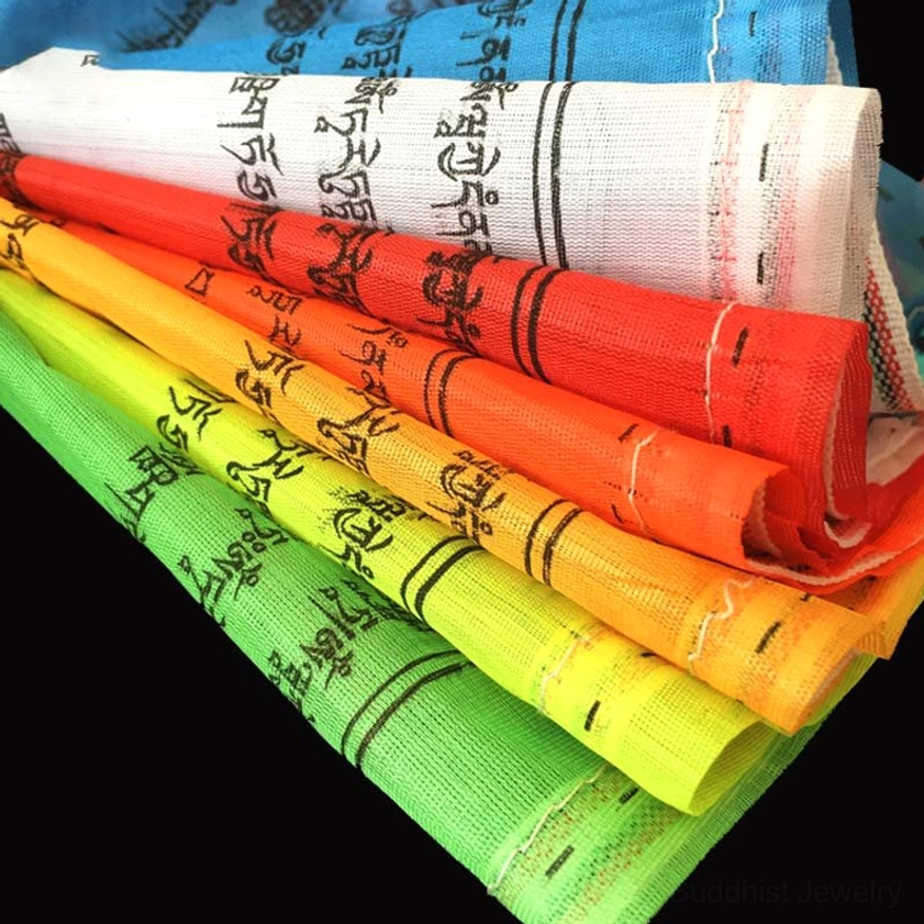 Arranged Buddhist prayer flags organized by traditional color sequence with clear detail of hand-printed mantras
