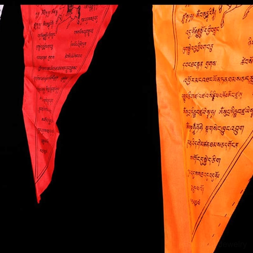 Individual triangular Buddhist prayer flag in bright red and orange showing detailed hand-printed sacred text
