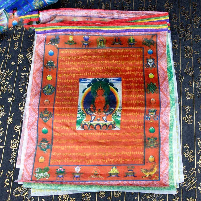 Stack of red Buddhist prayer flags with central Buddha image and eight auspicious Buddhist symbols in detail
