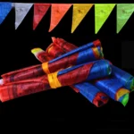 Rolled Buddhist prayer flags bundle wrapped with fabric straps showing vibrant five-color design against black background