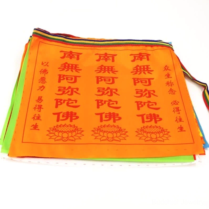 Stacked Buddhist prayer flags set showing layered orange-yellow satin fabric with side ties, studio flat view of multiple flag pieces