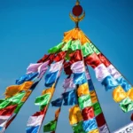 Buddhist prayer flags with windhorse design strung outdoors against blue sky showing traditional five-color arrangement
