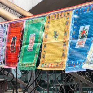 Colorful Buddhist prayer flags with traditional five-color windhorse design hung outdoors on balcony railing