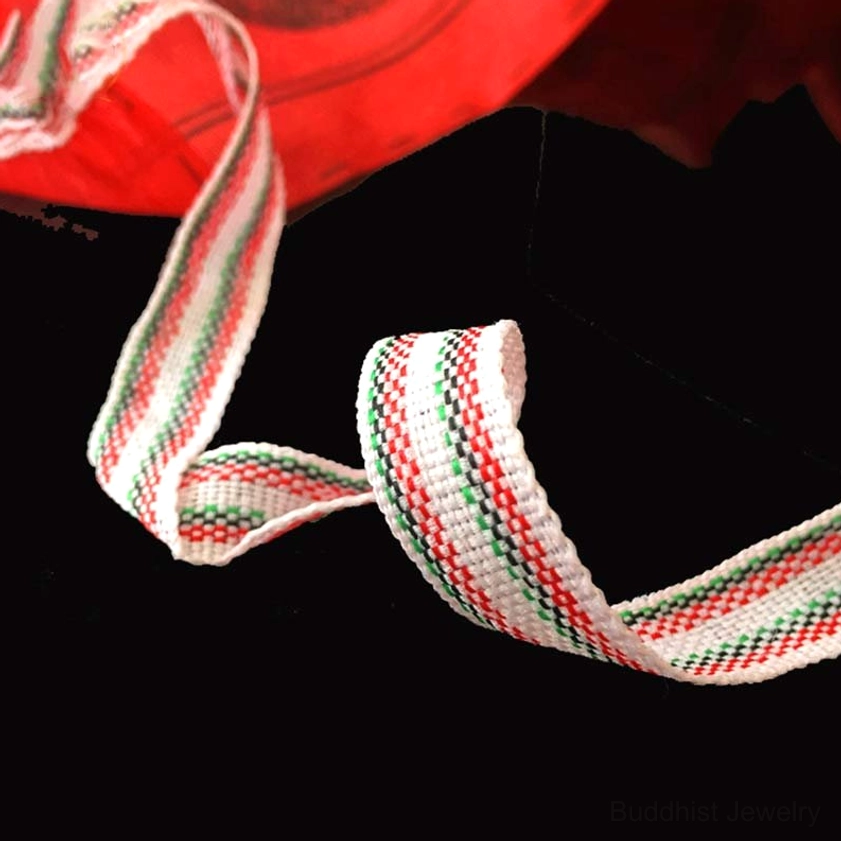 Buddhist prayer flags woven straps close-up showing red-white-green traditional binding attachment