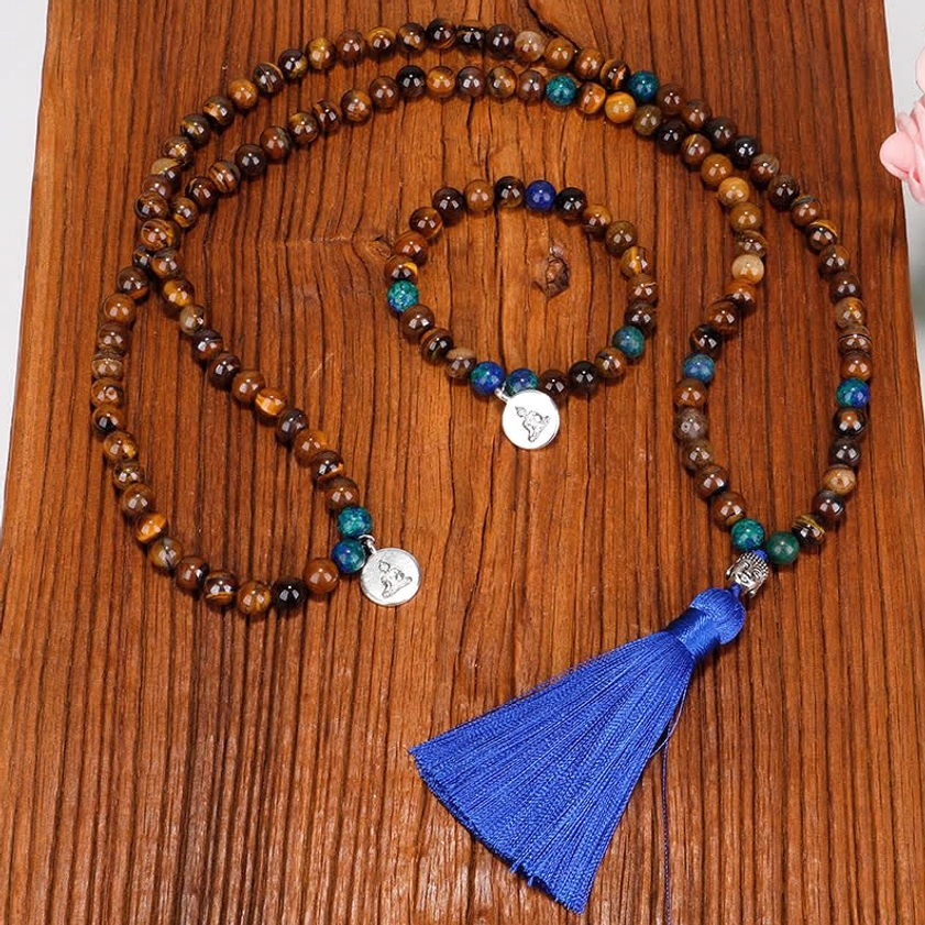 108 mala prayer beads bracelet flat lay with Buddha pendant and blue tassel