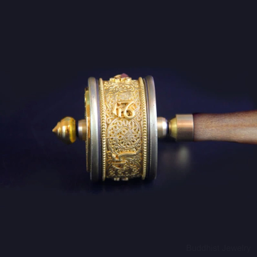 Close-up detailed view of Buddhist prayer wheel brass components and intricate embossed patterns on copper surface