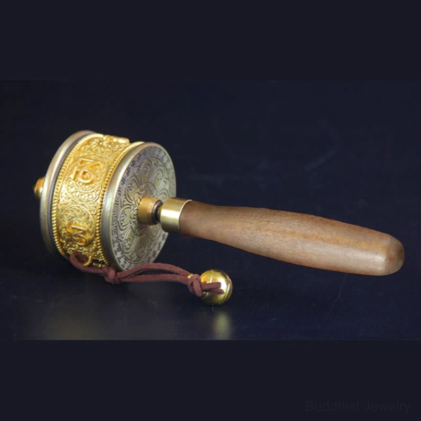 Copper prayer wheel left profile displaying embossed mantra carvings and gold-toned metal components