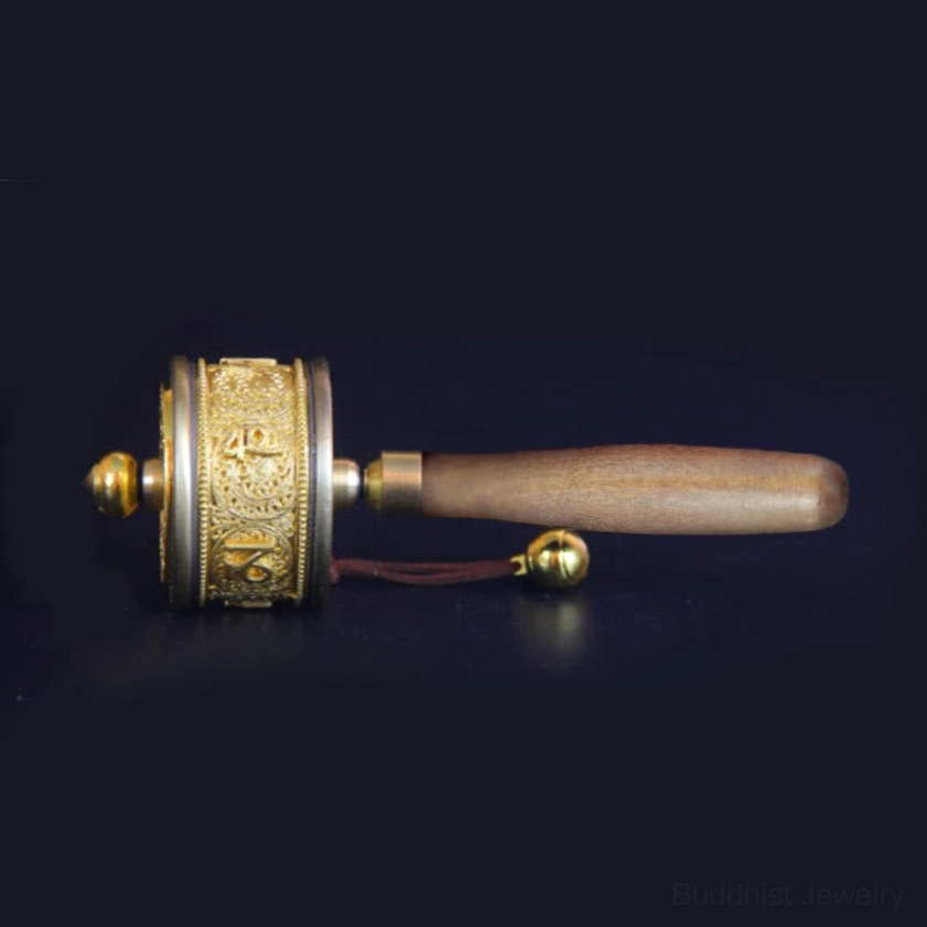 Compact handheld Buddhist prayer wheel with wooden handle and exposed sutra carvings for portable meditation