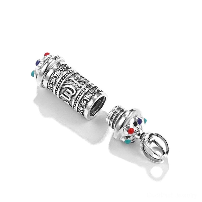 Buddhist prayer wheel pendant disassembled showing screw-on storage cap, hollow interior with engraved details and colored gems