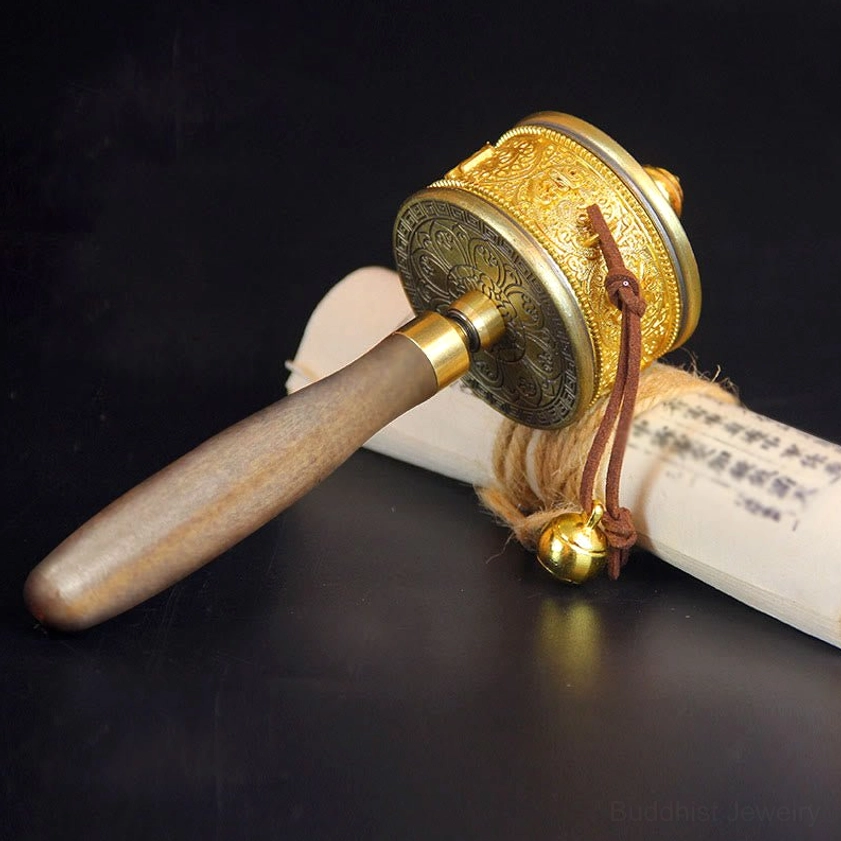 Side view of handmade Buddhist prayer wheel with leather lanyard and polished brass components for spiritual practice