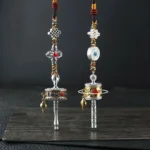 Tibetan Buddhist prayer wheel car hanging ornament with silver tone, colorful braided cord, and auspicious knot decorations - front flat view