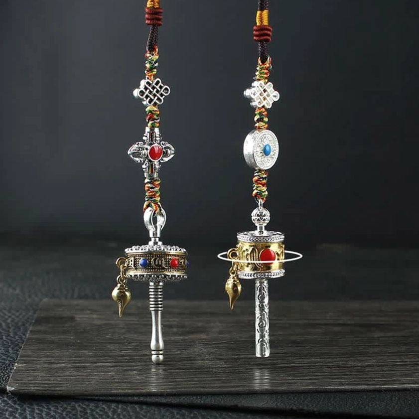 Tibetan Buddhist prayer wheel car hanging ornament with silver tone, colorful braided cord, and auspicious knot decorations - front flat view