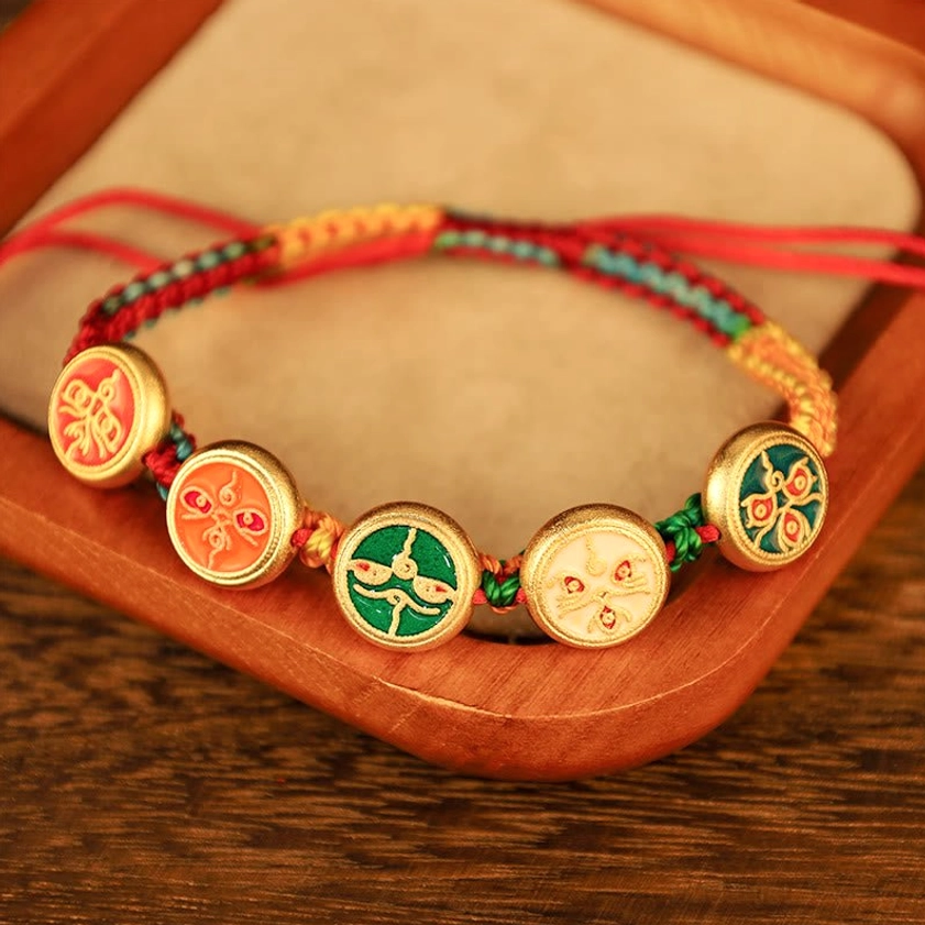Buddhist prosperity bracelet with five enamel charms on velvet jewelry display tray, detailed view of wealth deity symbols