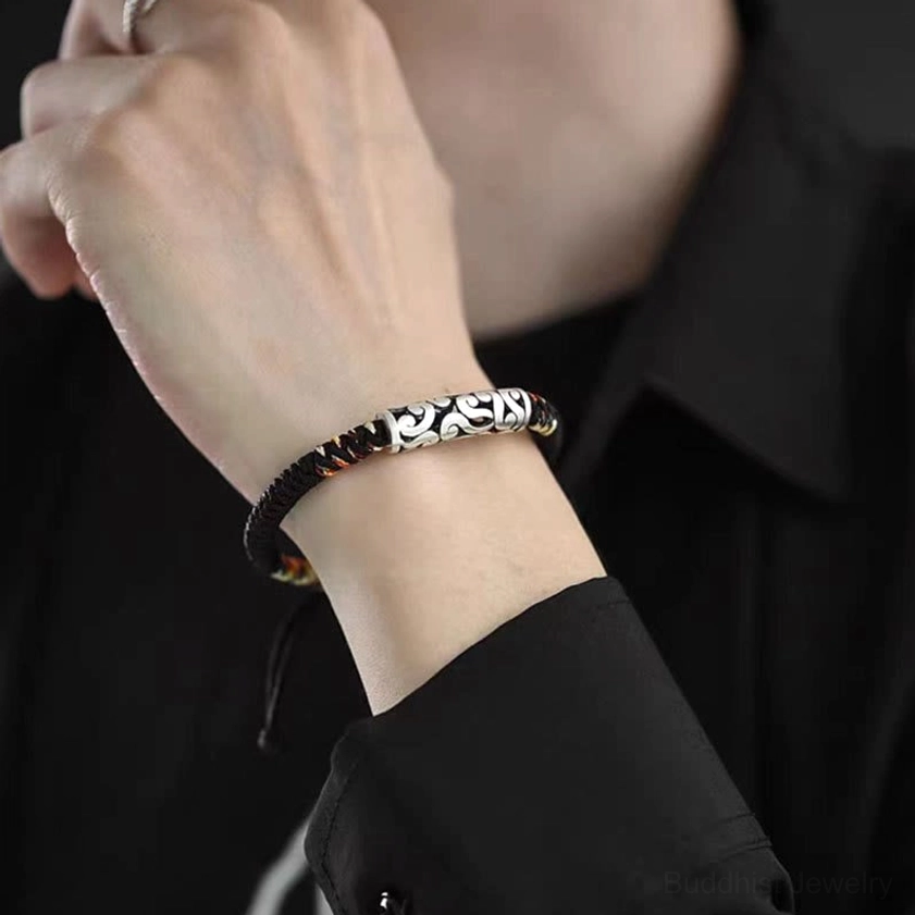 Buddhist string bracelet for prosperity worn on wrist with black collared shirt, showing perfect fit and design consistency